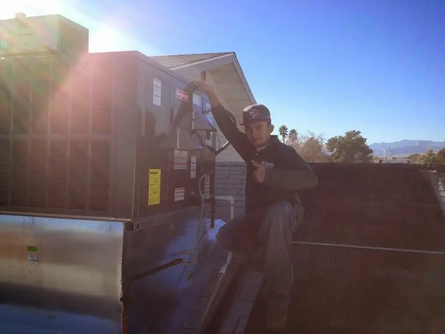 HVAC technician performing AC Tune-Up on a rooftop unit in Marysville